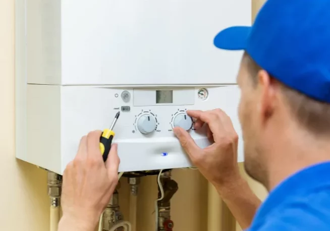 plumber-working-on-water-heater-repair-using-a-screwdriver-johnstown-co